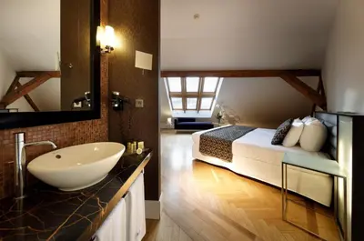 a bathroom with a sink and a bed in a room at Eurostars Thalia in Prague