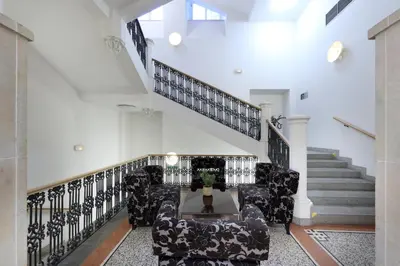 a living room with black chairs and a staircase at Eurostars Thalia in Prague