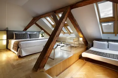 a attic bedroom with two beds and a table at Eurostars Thalia in Prague