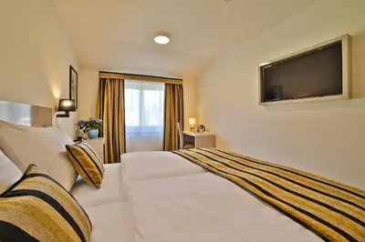 a hotel room with two beds and a flat screen tv at Hotel Ariston Prague in Prague
