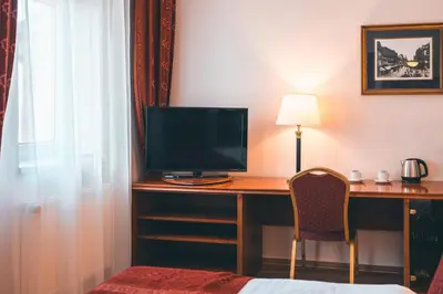 a hotel room with a desk with a television on it at Hotel Ariston Prague in Prague