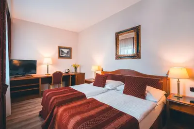 a hotel room with a bed and a desk at Hotel Ariston Prague in Prague