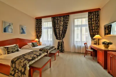 a hotel room with two beds and a desk at Carlton in Prague