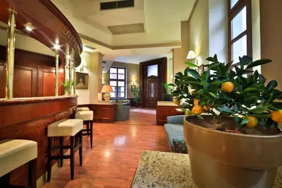 a lobby with a bar with a plant in a pot at Carlton in Prague