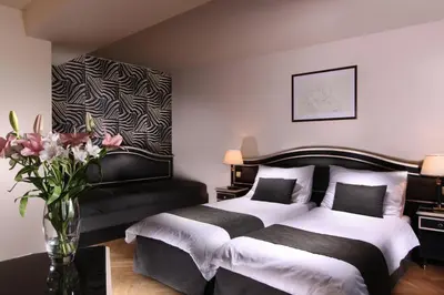 a bedroom with two beds and a vase of flowers at Elysee Hotel in Prague