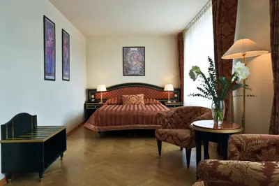 a bedroom with a bed and a couch and a table at Elysee Hotel in Prague