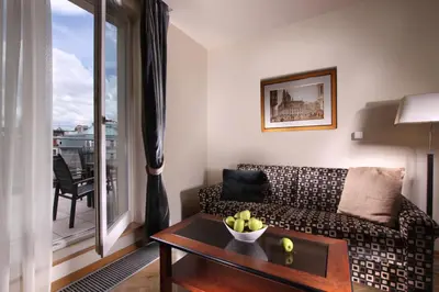 a living room with a couch and a table with a bowl of fruit at Elysee Hotel in Prague