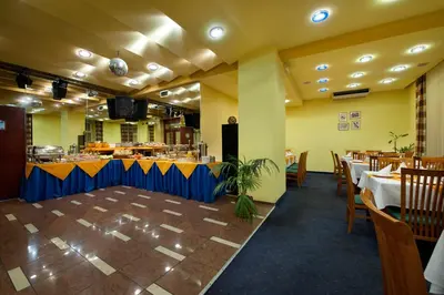 a restaurant with tables and chairs and a counter at Hotel Henrietta in Prague