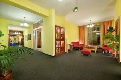 a lobby with yellow walls and red chairs and a waiting room at Hotel Henrietta in Prague