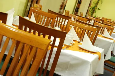 a row of tables and chairs with white napkins on them at Hotel Henrietta in Prague