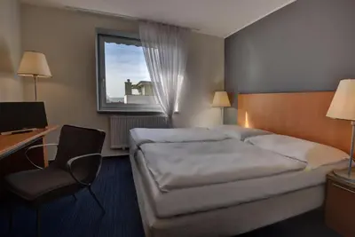 a hotel room with two beds and a desk and a computer at Hotel Henrietta in Prague