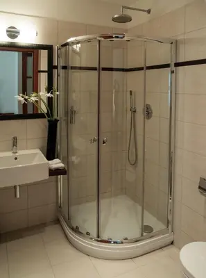 a bathroom with a glass shower and a sink at Design Merrion Residence in Prague