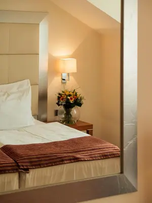 a mirror reflection of a bed in a hotel room at Design Merrion Residence in Prague