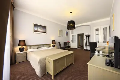 a bedroom with a bed and a desk and a television at Hotel Salvator in Prague