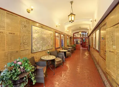 a hallway with tables and chairs and maps on the walls at Hotel Salvator in Prague