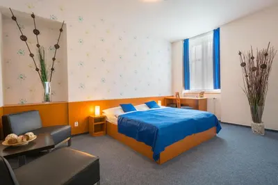 a hotel room with a bed and a table and chairs at Adeba Hotel in Prague