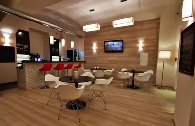 a restaurant with tables and chairs and a bar at Adeba Hotel in Prague
