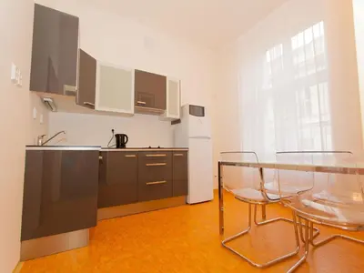 a kitchen with two clear chairs and a glass table at Adeba Hotel in Prague