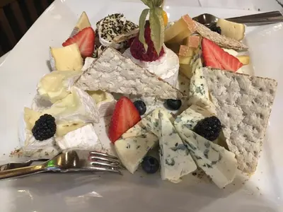 a plate of food with cheese and fruit on it at Admiral Botel in Prague