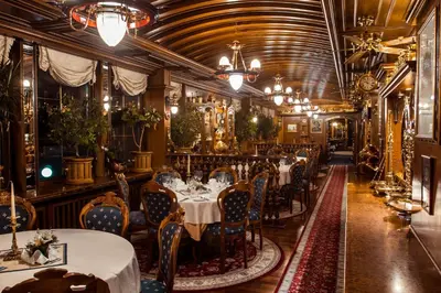 a dining room with tables and chairs and chandeliers at Admiral Botel in Prague