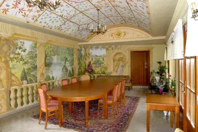 a dining room with a table and chairs and windows at Hotel Nosal in Prague