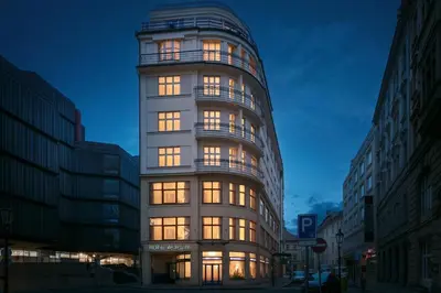 a tall building with many windows at night at Astoria Hotel in Prague