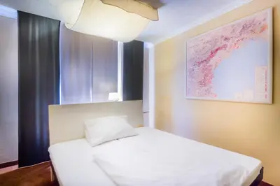 a bedroom with a white bed and a large window at Villa St. Tropez in Prague
