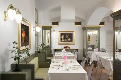 a restaurant with white tables and chairs and flowers at Hotel Liberty in Prague