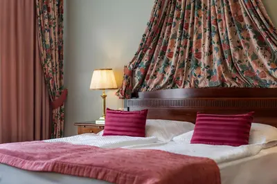 a bedroom with a bed with two purple pillows at Hotel Liberty in Prague