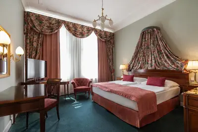 a hotel room with a bed and a desk at Hotel Liberty in Prague