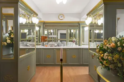 a kitchen with green cabinets and flowers and a clock at Hotel Liberty in Prague