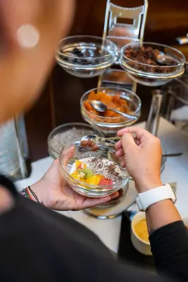 a group of people holding bowls of food on a table at Hotel Liberty in Prague