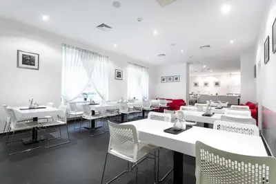 a dining room with white tables and white chairs at My Hotel Apollon in Prague