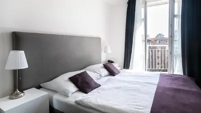 a bedroom with a bed with a large window at My Hotel Apollon in Prague