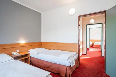 a hotel room with two beds and a mirror at Hotel Globus in Prague