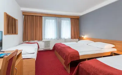 a hotel room with two beds and a television at Hotel Globus in Prague
