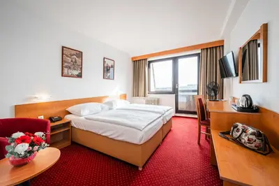 a hotel room with a bed and a desk at Hotel Globus in Prague