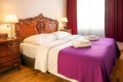 a bedroom with a bed with a purple blanket at BHG Apartments Prague in Prague