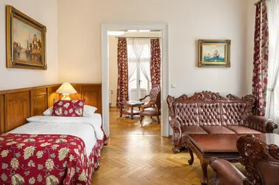 a dining room with a table and chairs and a couch at BHG Apartments Prague in Prague