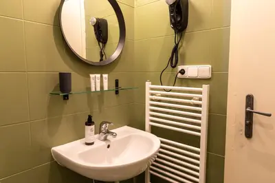 a bathroom with a sink and a mirror and a phone at Sir Toby's Midtown in Prague