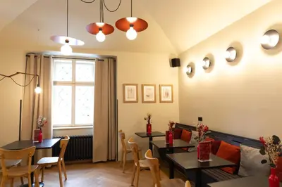 a dining room with two tables and chairs and a window at Sir Toby's Midtown in Prague