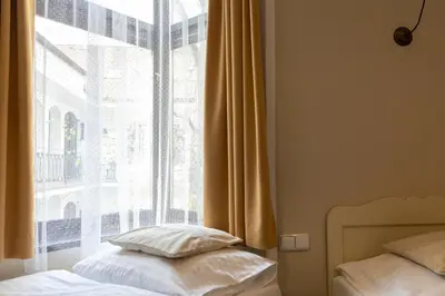 a bed with two pillows sitting next to a window at Sir Toby's Midtown in Prague