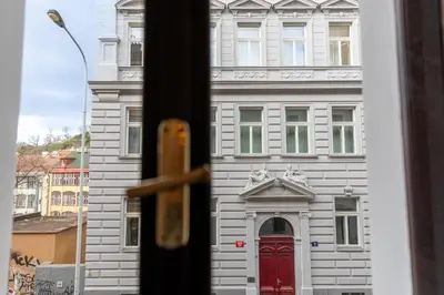 a window view of a white building with a red door at Sir Toby's Midtown in Prague