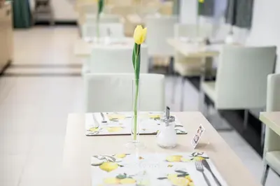 a yellow flower in a vase on a table at Hotel Páv in Prague