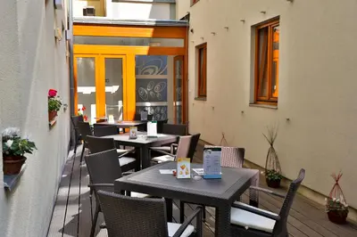 a patio with tables and chairs on a balcony at Hotel Páv in Prague