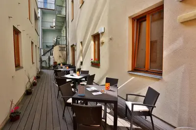 a restaurant with tables and chairs on a balcony at Hotel Páv in Prague