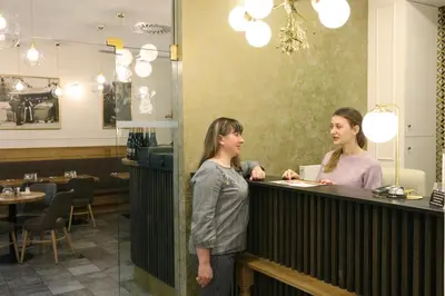 two women standing at a counter in a restaurant at U Stare Pani - At the Old Lady Hotel in Prague