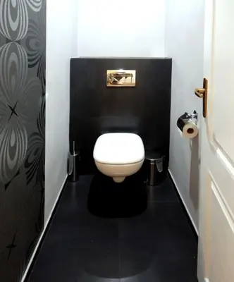 a bathroom with a white toilet in a black wall at U Stare Pani - At the Old Lady Hotel in Prague