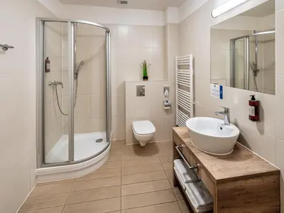 a bathroom with a shower and a sink and a toilet at Hotel 