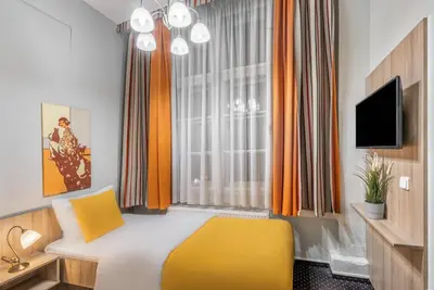 a bedroom with a yellow bed and a window at Hotel 